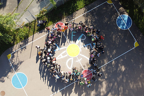 Schülergruppe im Kreis stehend und aus der Luft fotografiert