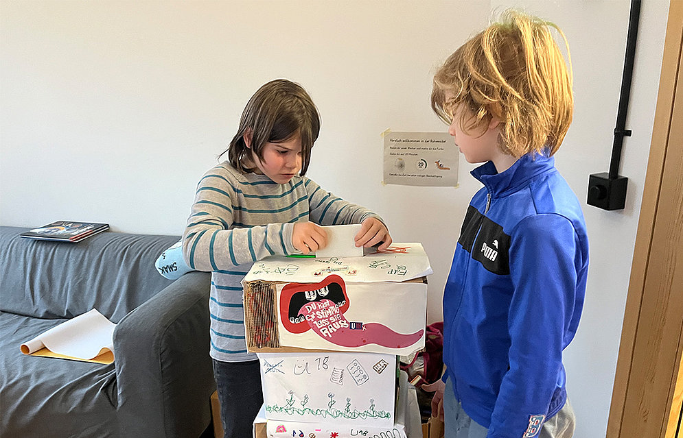 Kinder basteln die Wahlkabine der U-18 Wahl an der Schöpflin Schule