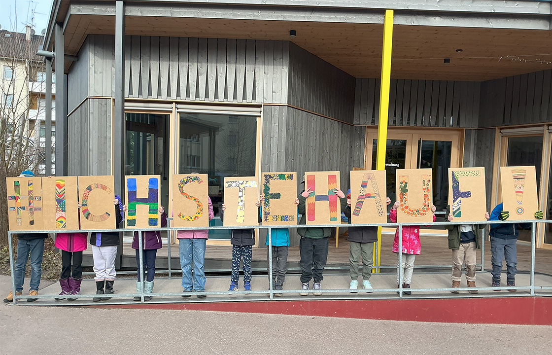 Bundesweite Aktion #IchStehAuf an der Schöpflin Schule, Kiunder halten kreativ gestaltete Schilder hoch