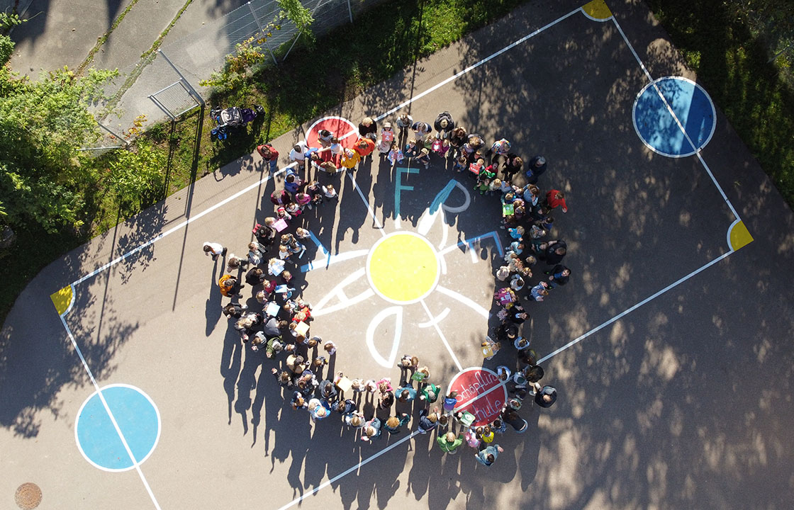Schülergruppe im Kreis stehend und aus der Luft fotografiert